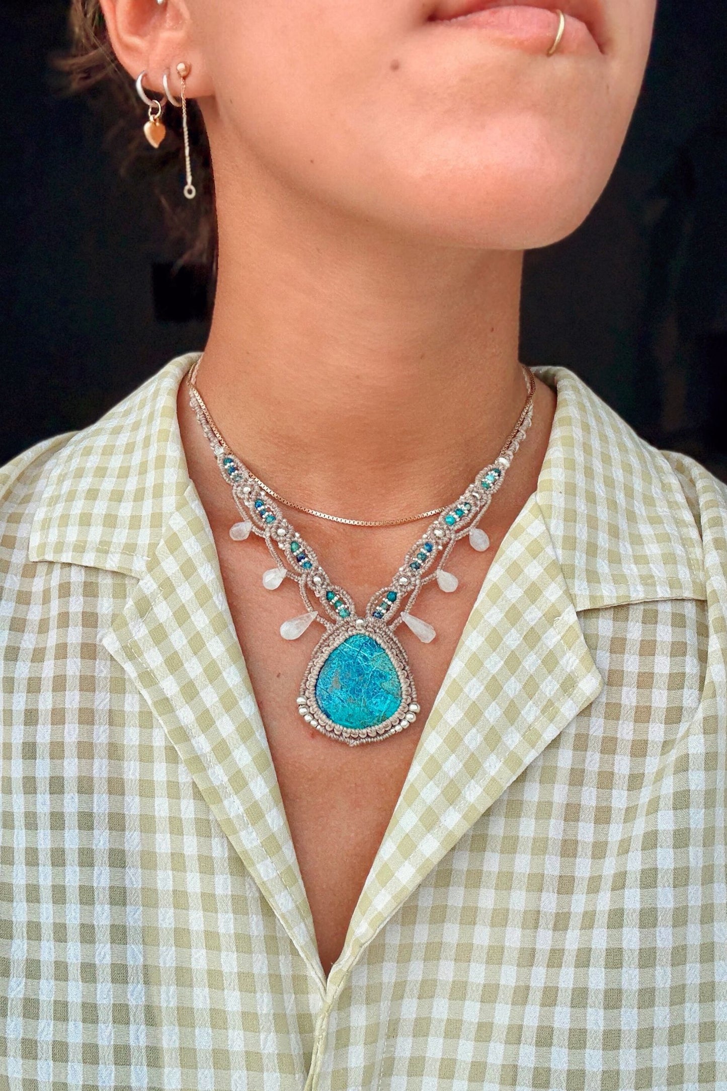 Model styling a one of a kind Chrysocolla V-shaped necklace, showcasing its statement design along the neckline