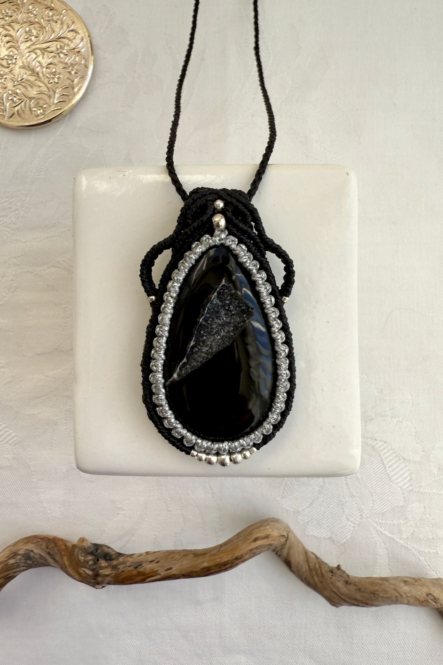 Handmade macrame necklace with Druzy Onyx gemstone, part of the Nocturnal Collection. One-of-a-kind design, laid flat for an artistic display.