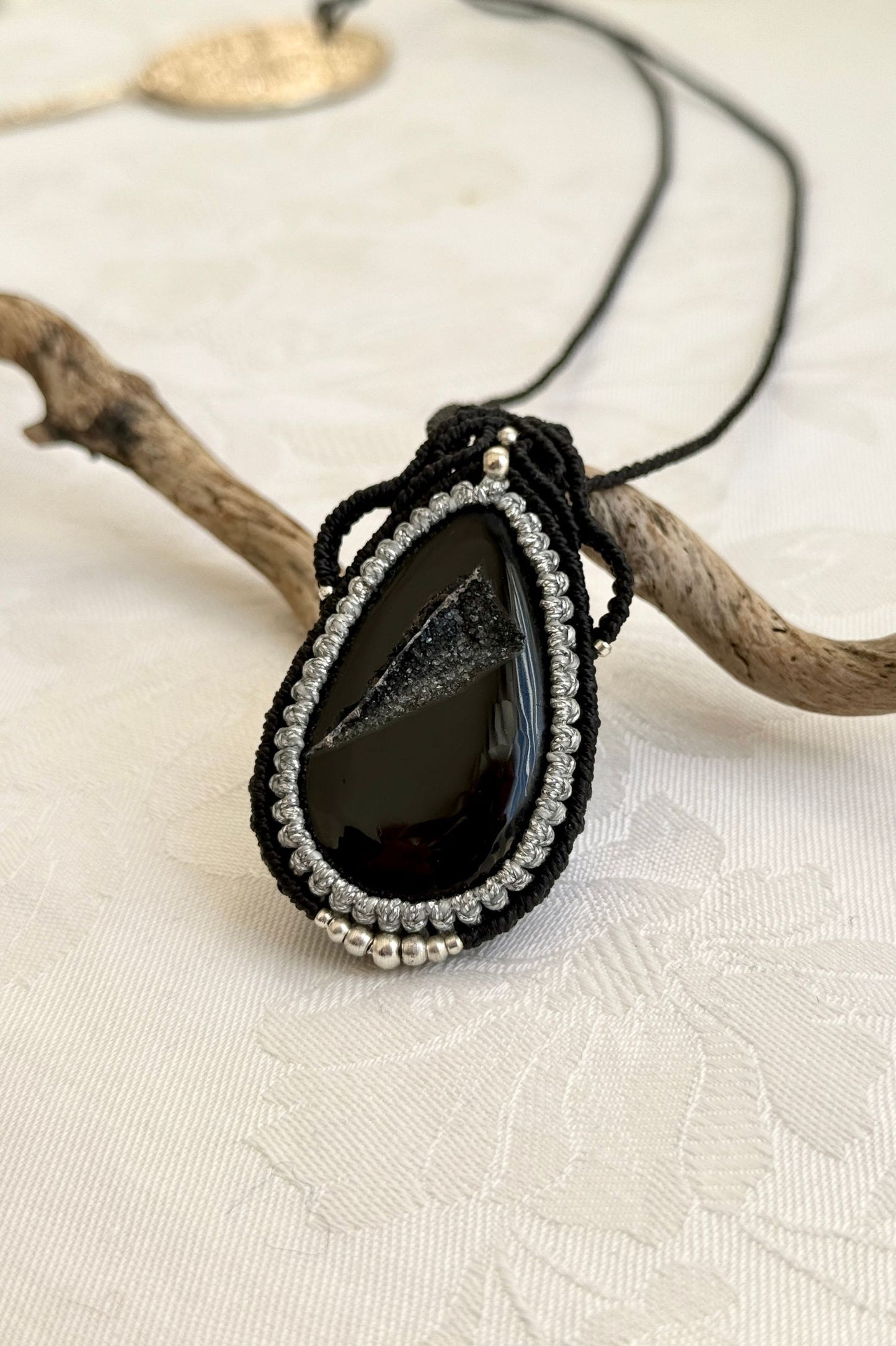 Close-up of the Druzy Onyx macrame necklace in a unique setting. Highlighting the craftsmanship and gemstone details.