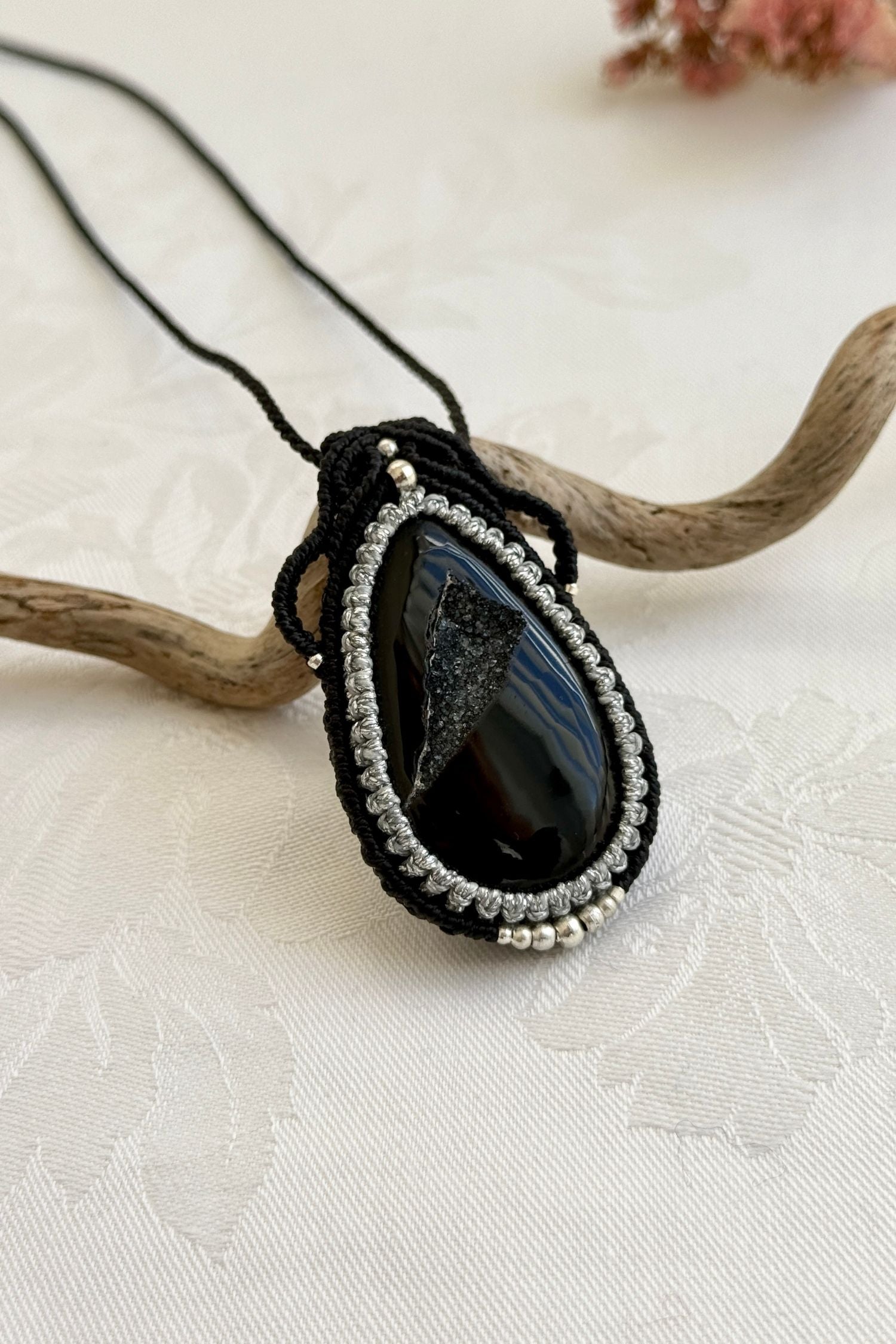 Side-angle view of the handmade macrame necklace with Druzy Onyx. Showcasing depth, knotting details, and stone textures.