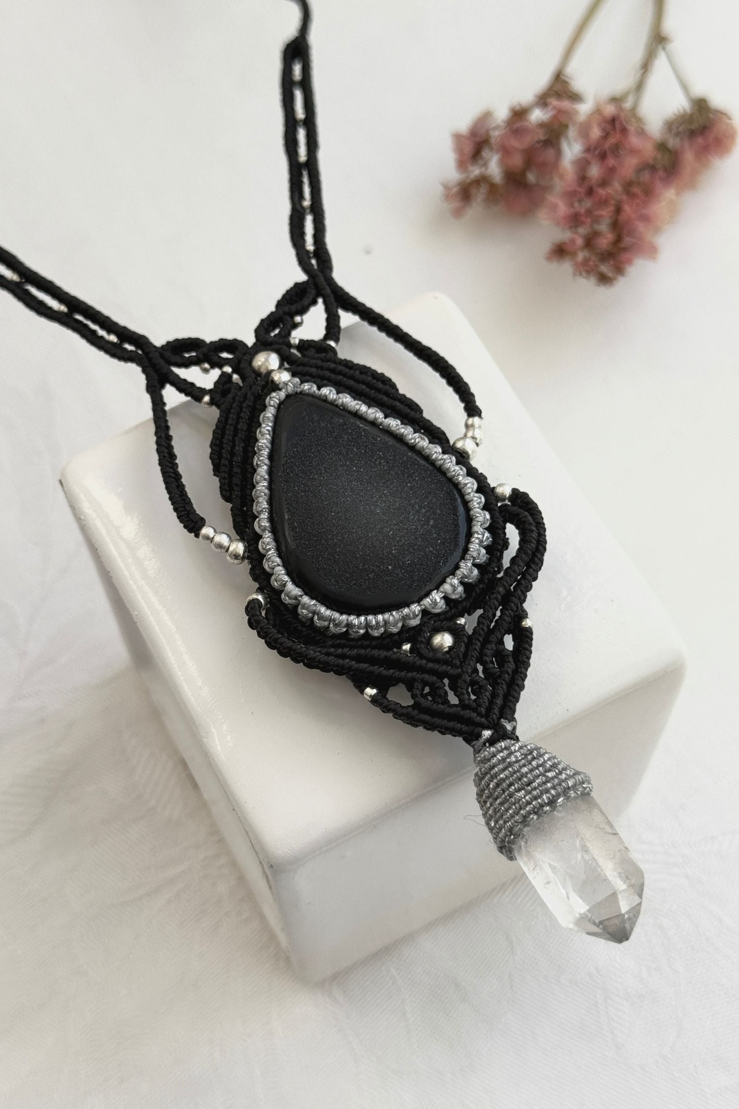 Detailed close-up of Druzy Onyx and Clear Quartz point gemstones in a handmade macrame necklace. Showcasing natural textures and gemstone glow.