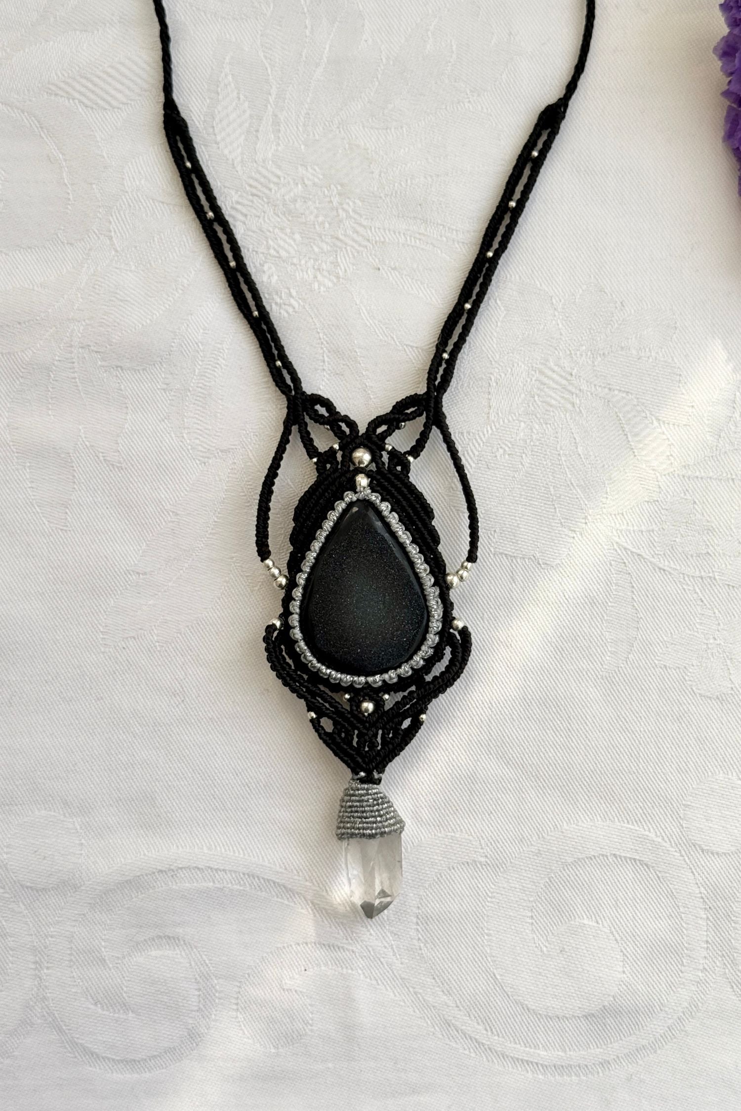 Close-up of the Druzy Onyx and Clear Quartz point macrame necklace in a unique setting. Highlighting the craftsmanship and gemstones details.