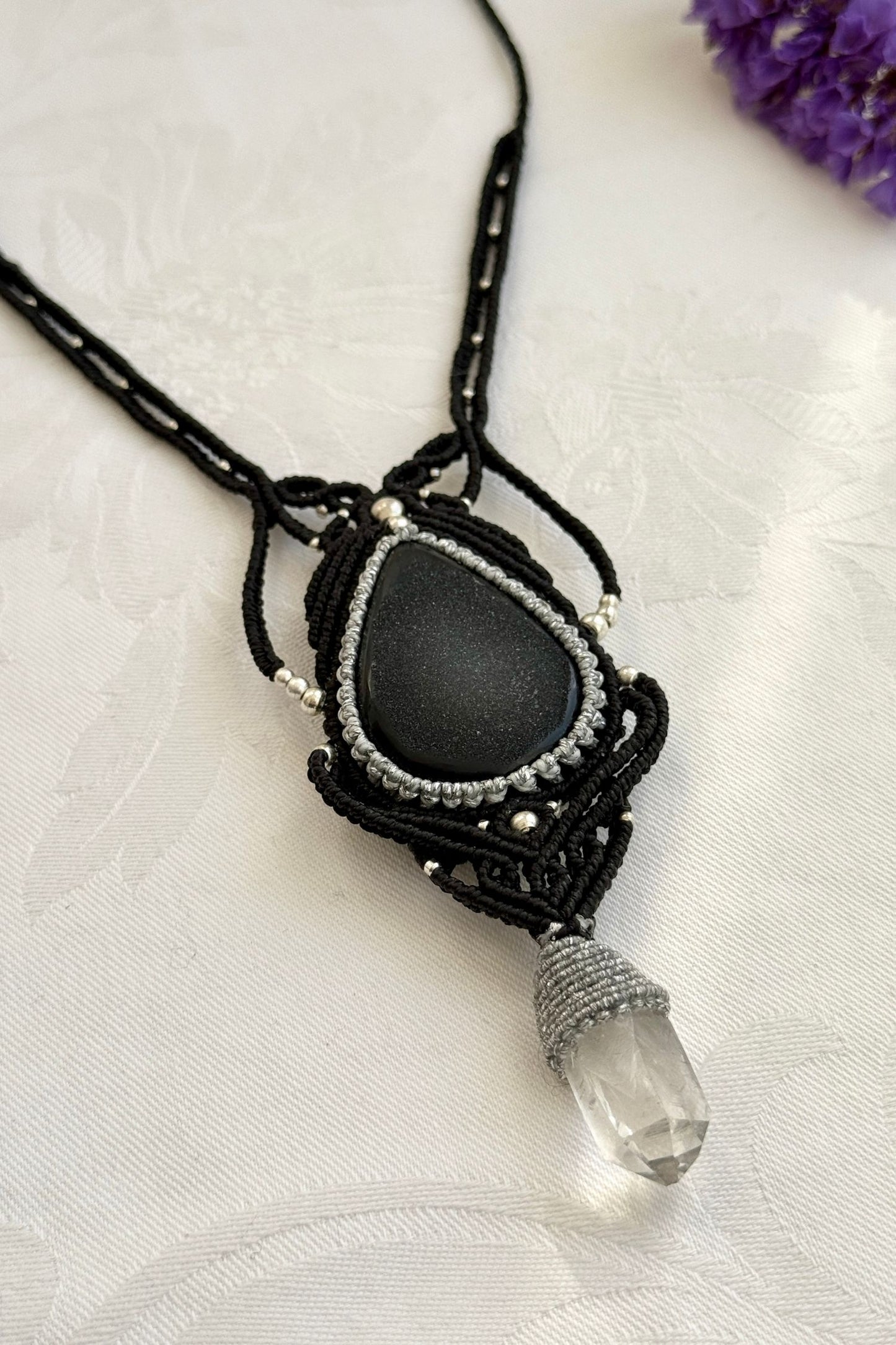 Side-angle view of the handmade macrame necklace with Druzy Onyx and Clear Quartz point. Showcasing depth, knotting details, and stone textures.