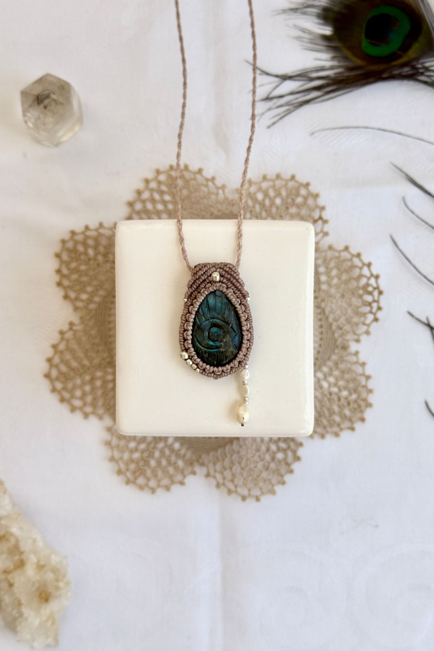 One-of-a-kind Labradorite necklace with carved protective eye, laid flat to highlight its unique shimmer and design.