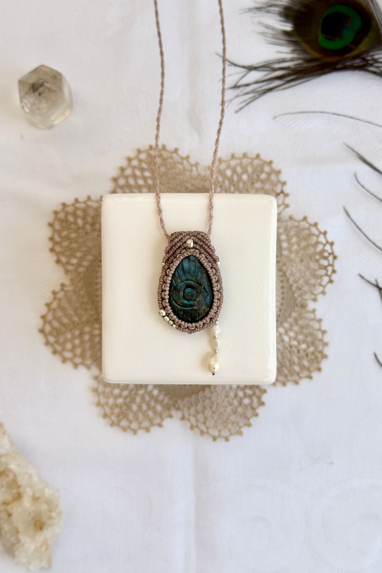 One-of-a-kind Labradorite necklace with carved protective eye, laid flat to highlight its unique shimmer and design.