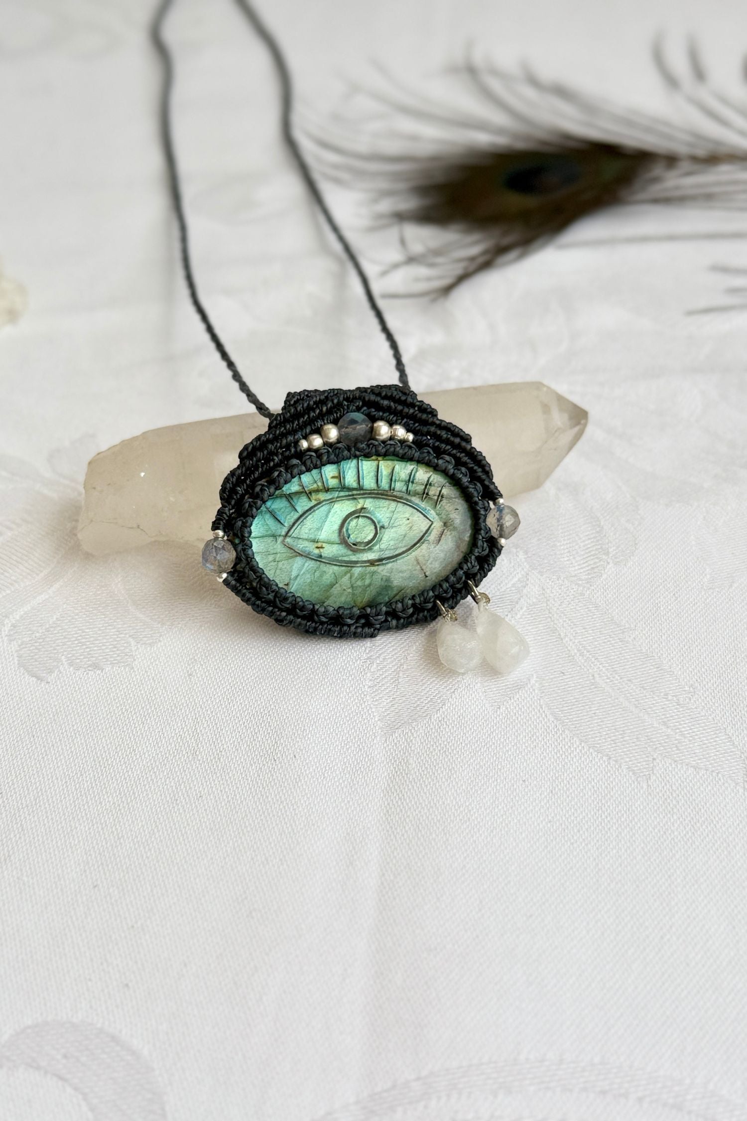 Artisan Labradorite protective eye necklace, shown from another angle to capture gemstone hues and macrame thread work.