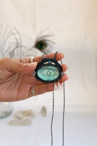 Hand holding handmade Labradorite macrame necklace with dangling Moonstone tears, showing the scale and carved gemstone details.