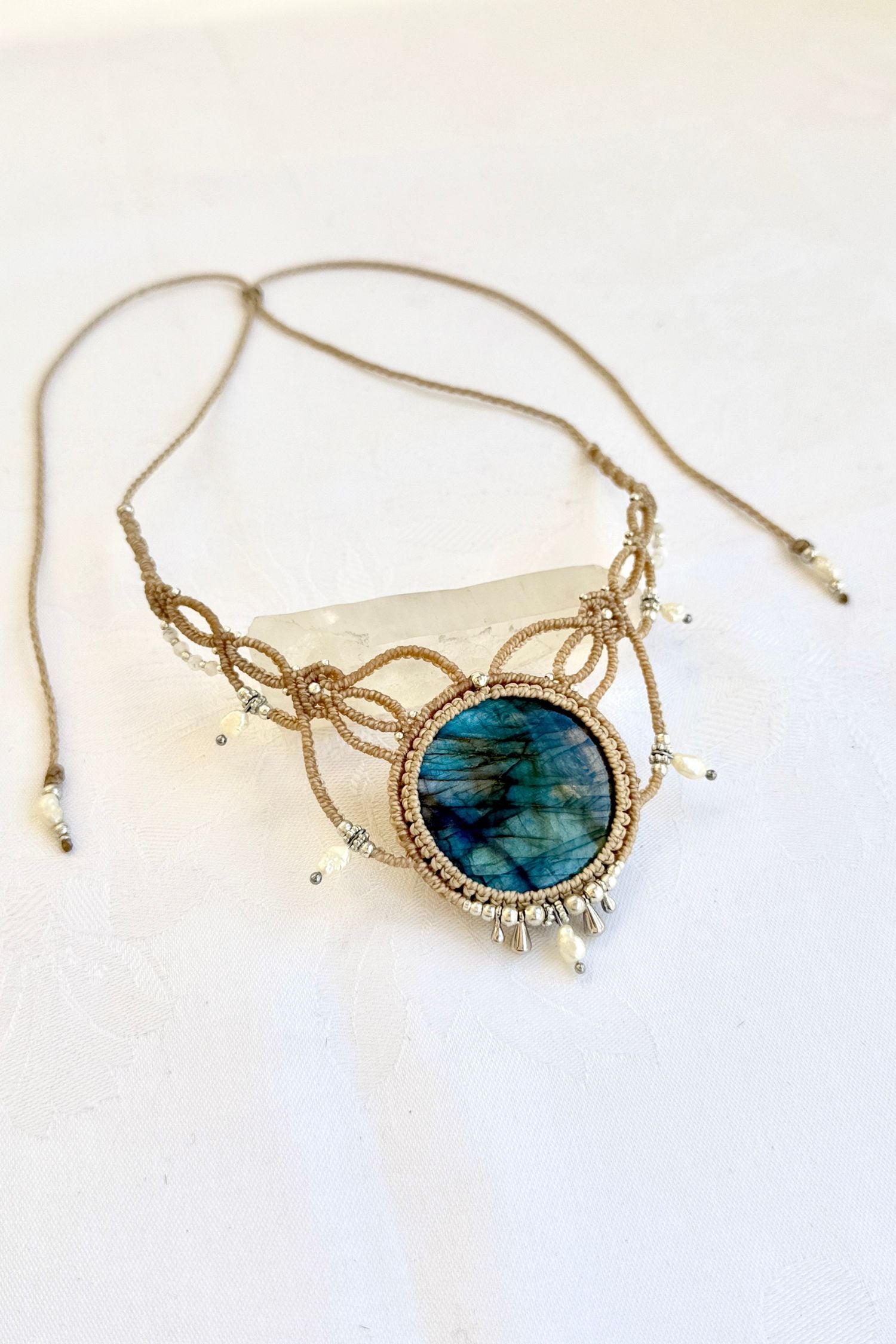 Side angle view of a one of a kind Labradorite necklace with pearl adornments and Victorian-inspired macramé design.