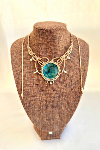 Labradorite macramé necklace displayed on bust, featuring deep blue gemstone and elegant pearl details.