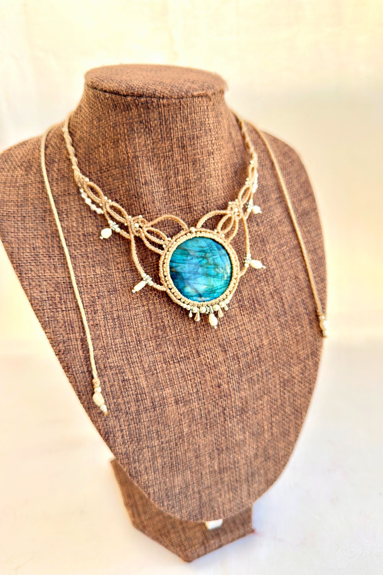 Angled view of Victorian-inspired Labradorite macramé necklace with freshwater pearls and silver bead accents.