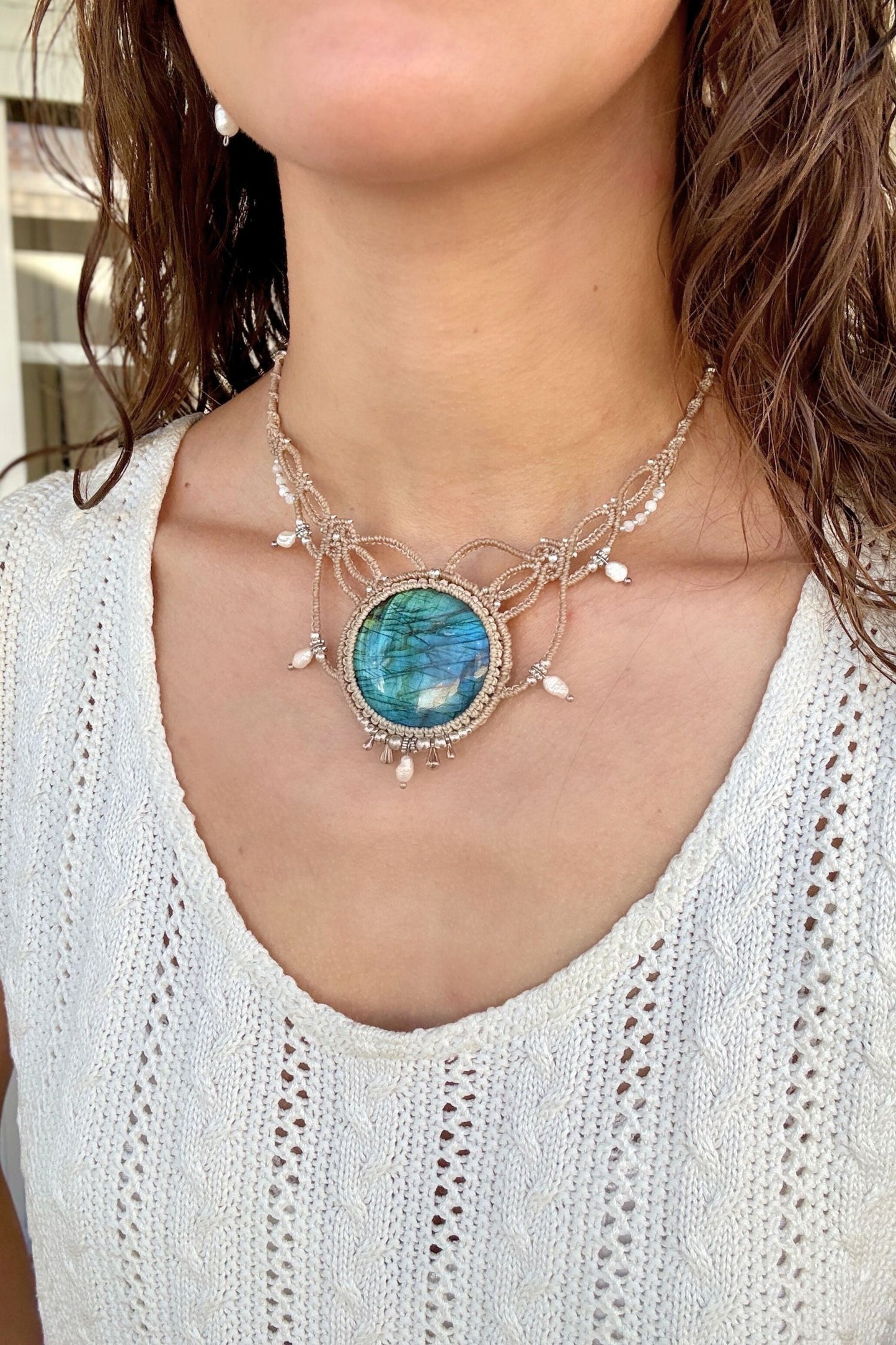 Model styling a one of a kind Labradorite macramé necklace with pearls, showcasing its statement and elegant design.