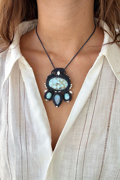 Model wearing a handmade Larimar and Moonstone macramé necklace with ocean-inspired blue tones and pearl accents