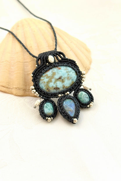 Close-up side view of Larimar and Moonstone gemstones in a handmade macramé necklace with silver bead details