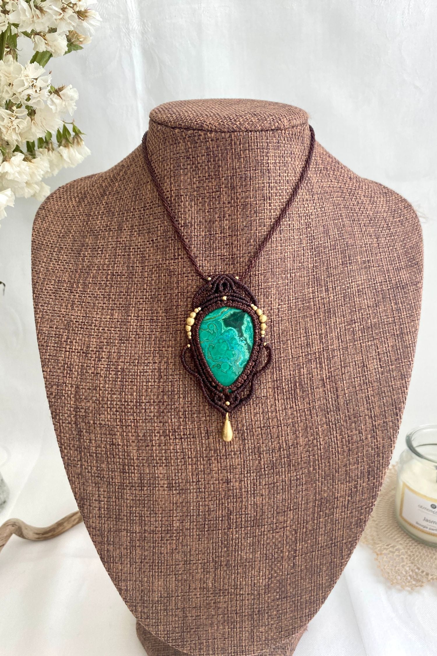 Artistic jewelry display of a one-of-a-kind macrame necklace, featuring hand-selected gemstones in a timeless and elegant design.