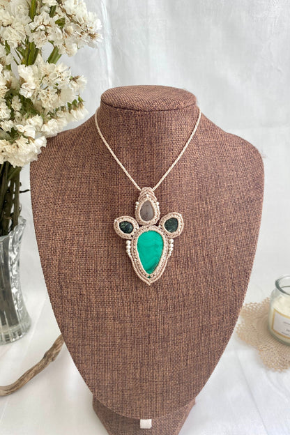 Artistic jewelry display of a one-of-a-kind macrame necklace, featuring hand-selected gemstones in a timeless and elegant design.
