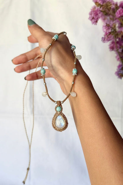 Rainbow Moonstone and Amazonite macrame necklace held in a hand, showing the pendant, gemstone beads and hanging drops.