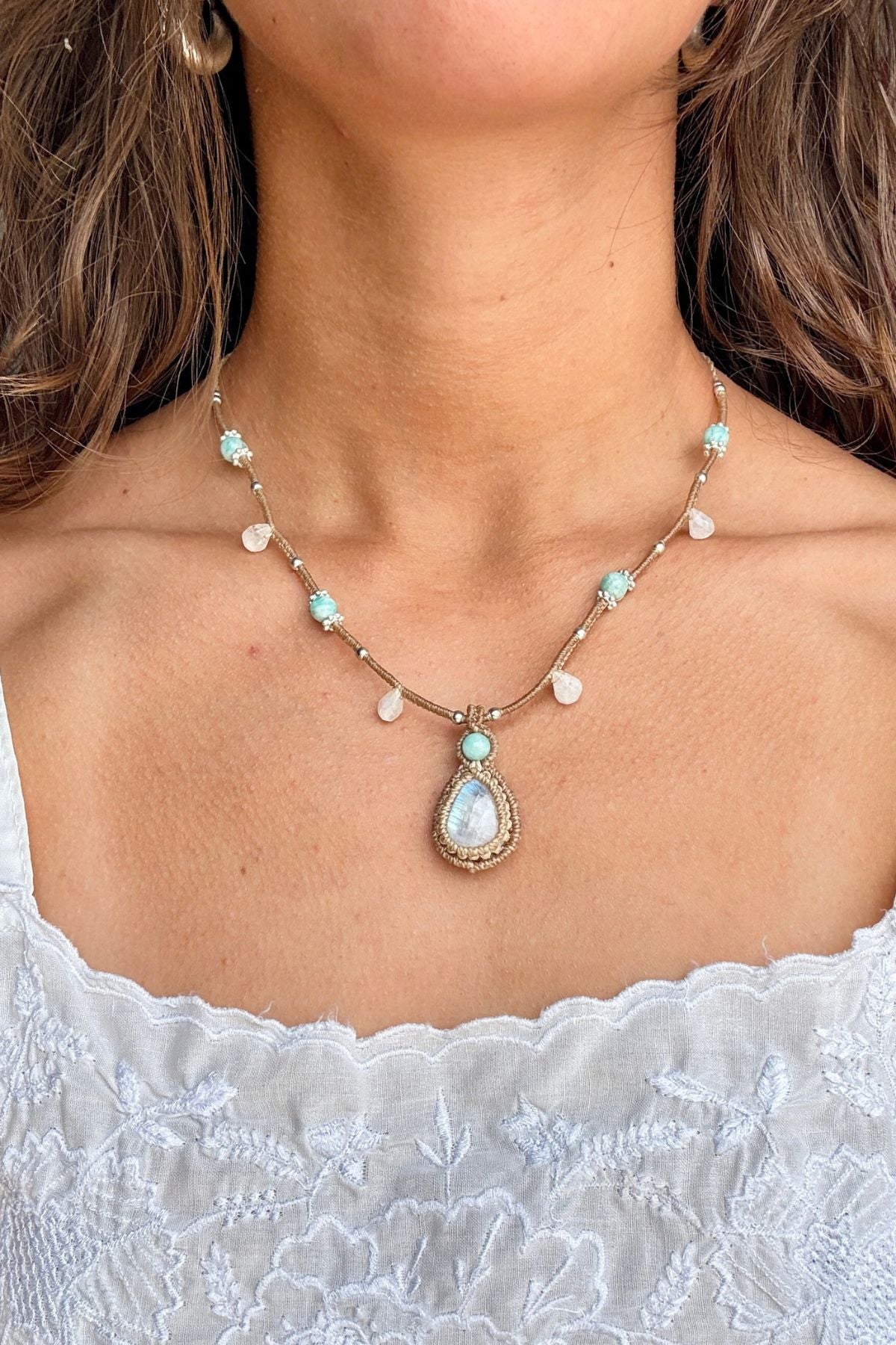 Rainbow Moonstone and Amazonite necklace worn with a white embroidered top, showing how the pendant sits on the chest.