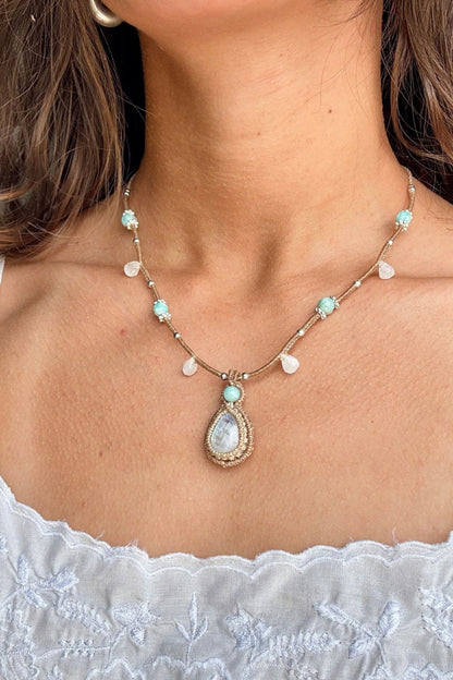 Closer view of the macrame necklace worn on the chest, showing its teardrop Moonstone pendant and spaced Amazonite beads.