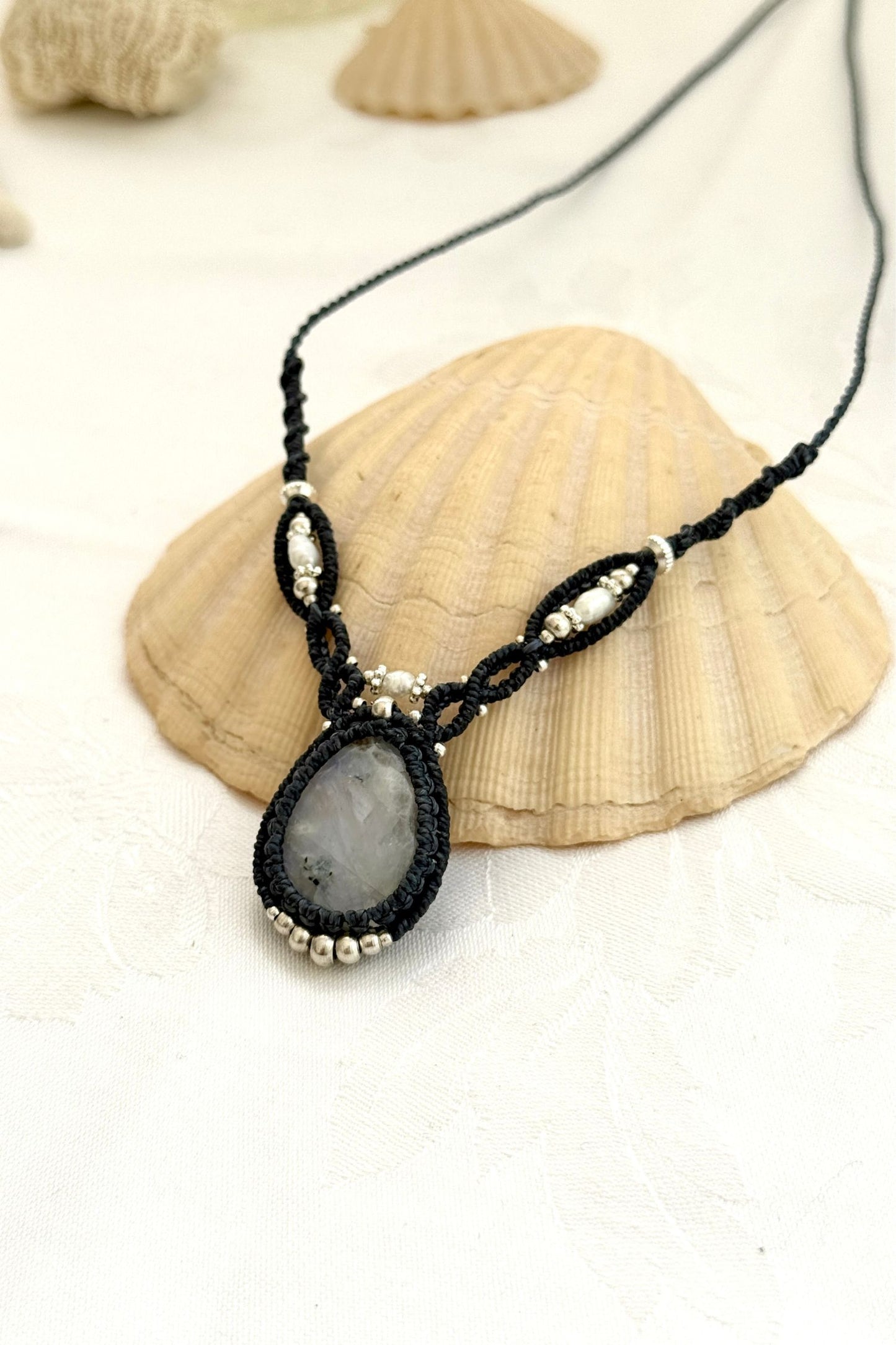 Side view of a handmade Moonstone macramé necklace showing layered design and navy blue cord texture