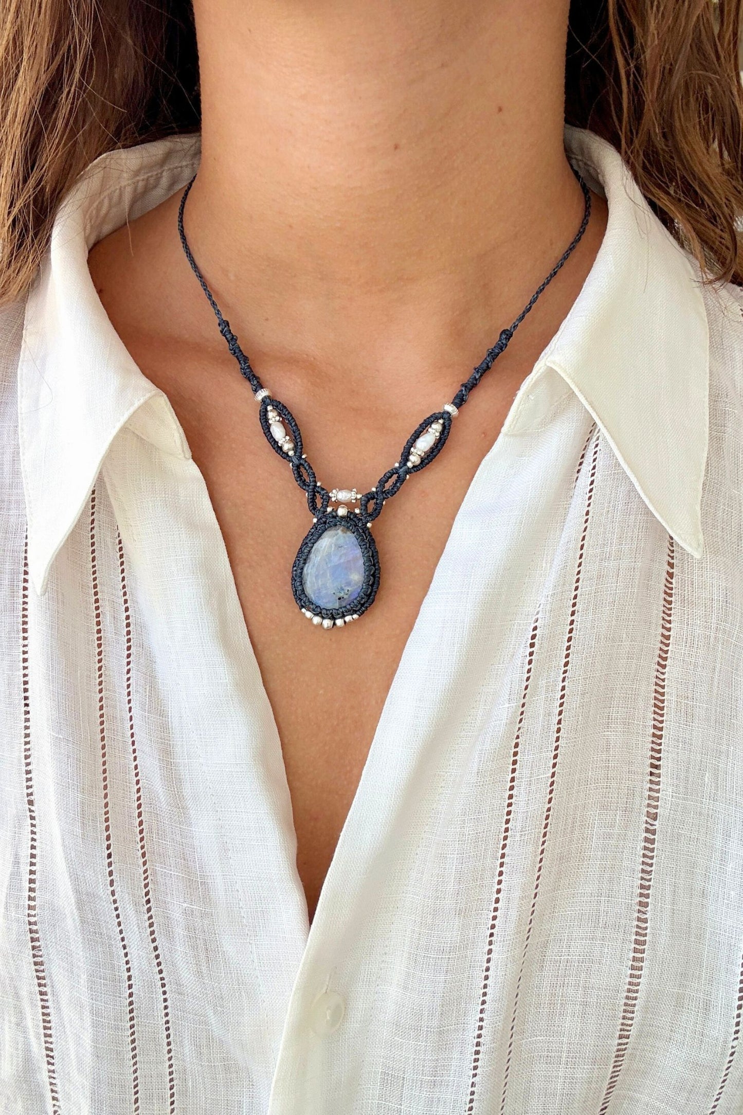 Model styling a one of a kind Moonstone V-shaped necklace, showcasing its statement design along the neckline