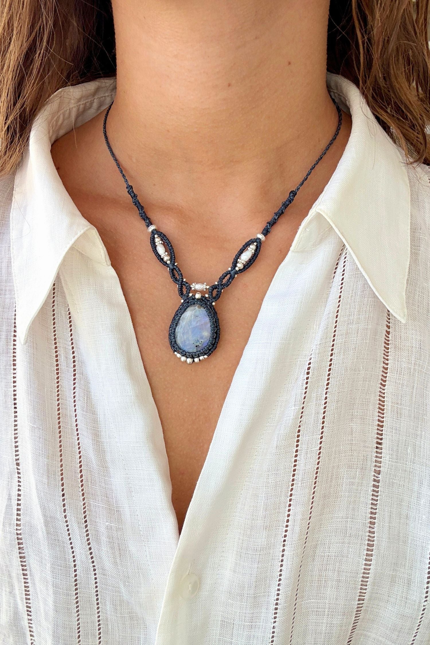 Model styling a one of a kind Moonstone V-shaped necklace, showcasing its statement design along the neckline