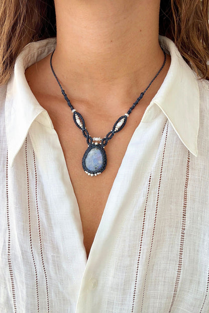 Model styling a one of a kind Moonstone V-shaped necklace, showcasing its statement design along the neckline