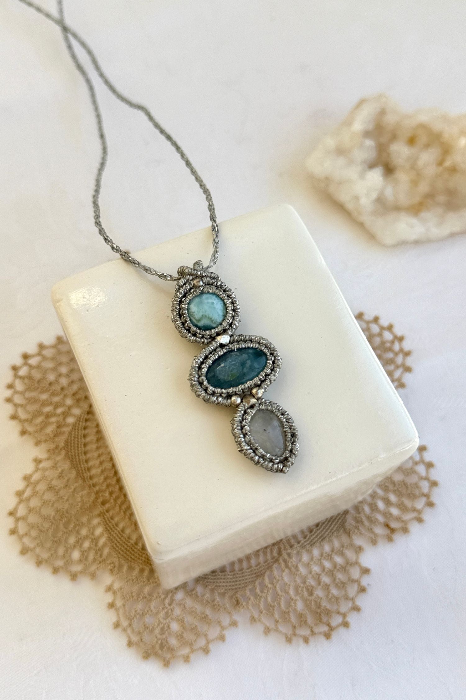 Detailed close-up of Larimar, Aquamarine and Moonstone gemstones in a handmade macrame necklace. Showcasing natural textures and gemstone glow.