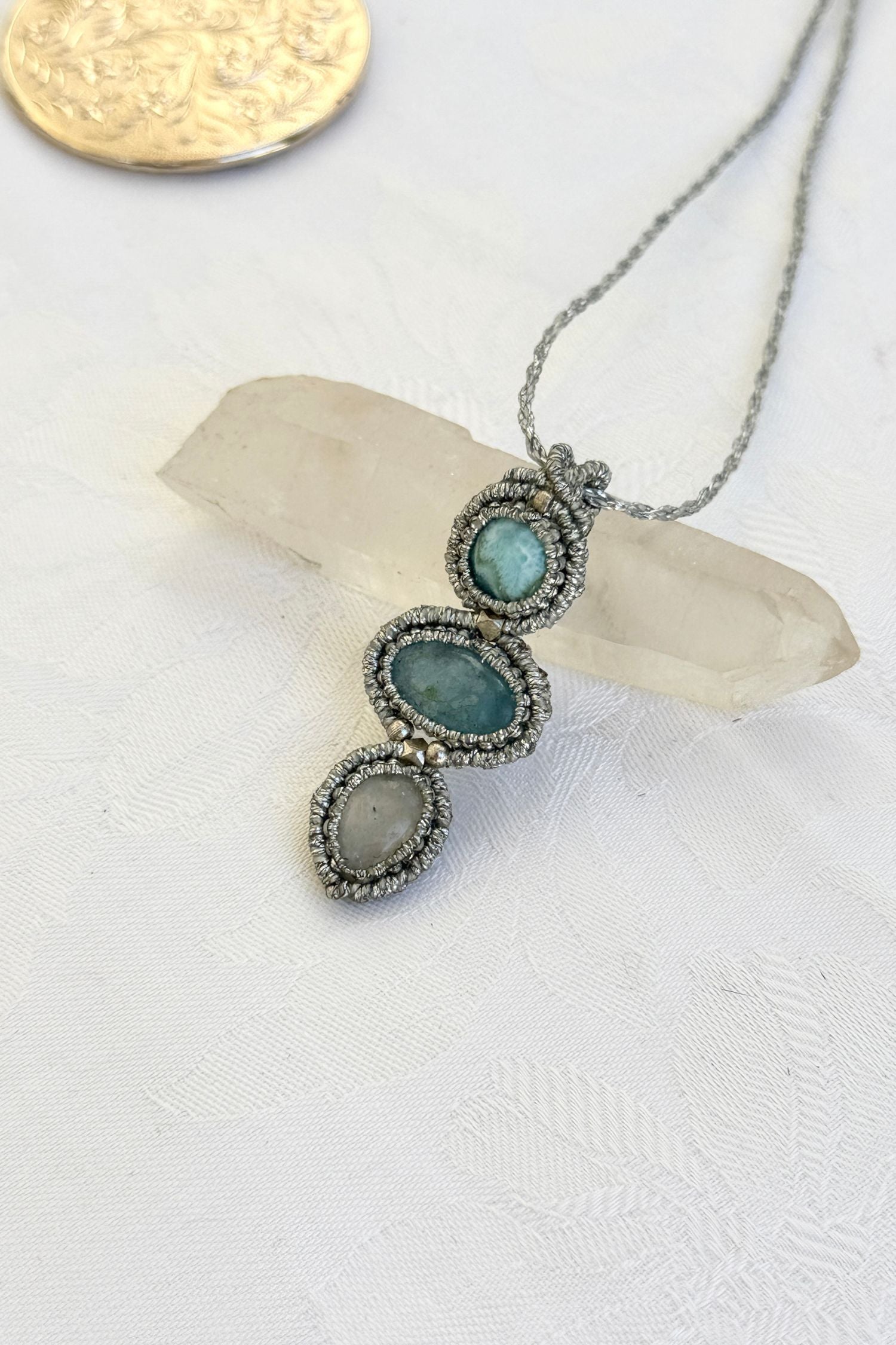 Side-angle view of the handmade macrame necklace with Larimar, Aquamarine and Moonstone. Showcasing depth, knotting details, and stone textures.