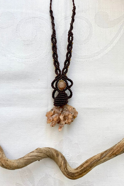 Artistic jewelry display of a one-of-a-kind macrame necklace, featuring hand-selected gemstones in a timeless and elegant design.