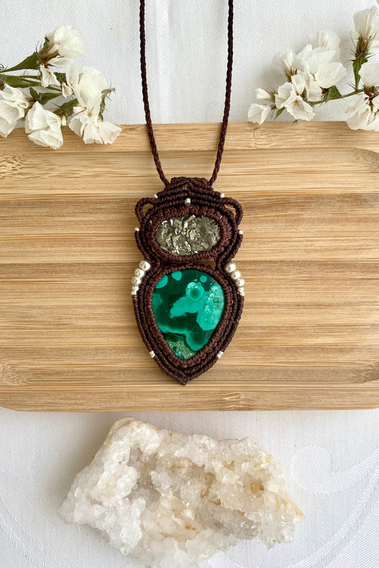 Handmade macrame necklace featuring natural malachite with vibrant green swirls and raw pyrite, centered on a clean background.