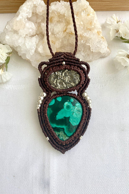 Handmade macrame necklace with natural malachite and raw pyrite on a clean white background, emphasizing the unique swirls of malachite.