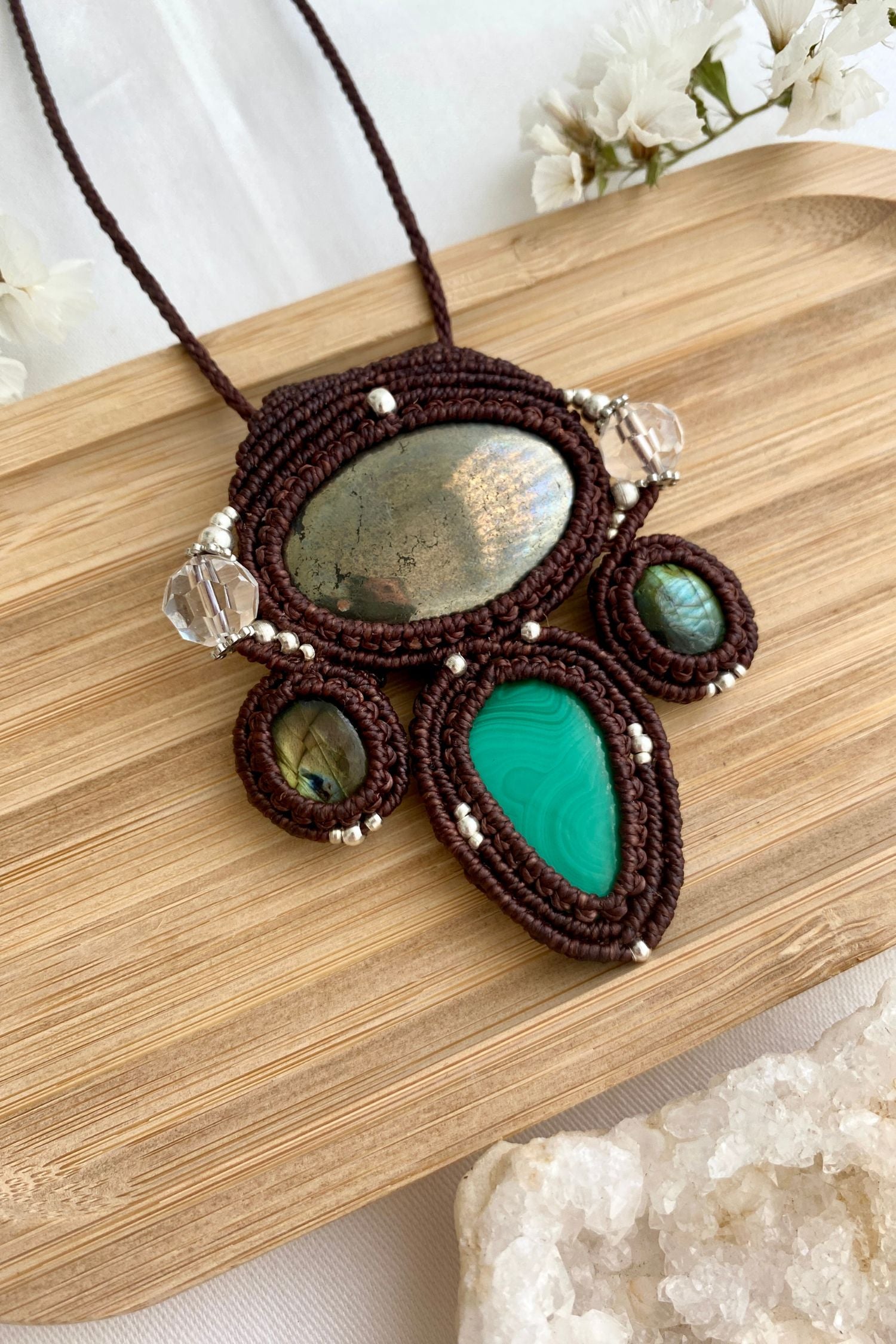 Detailed view of the handmade necklace, highlighting the raw textures of natural Pyrite, Labradorite, Malachite and Quartz gemstones in a distinctive, statement-making design.