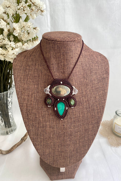 Artistic jewelry display of a one-of-a-kind macrame necklace, featuring hand-selected gemstones in a timeless and elegant design.