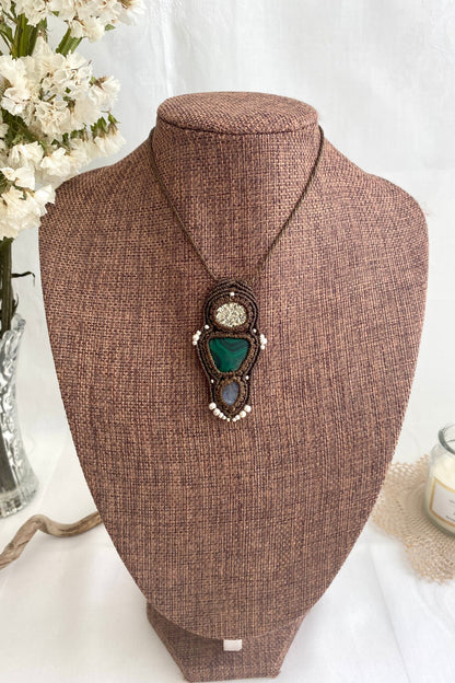 Artistic jewelry display of a one-of-a-kind macrame necklace, featuring hand-selected gemstones in a timeless and elegant design.