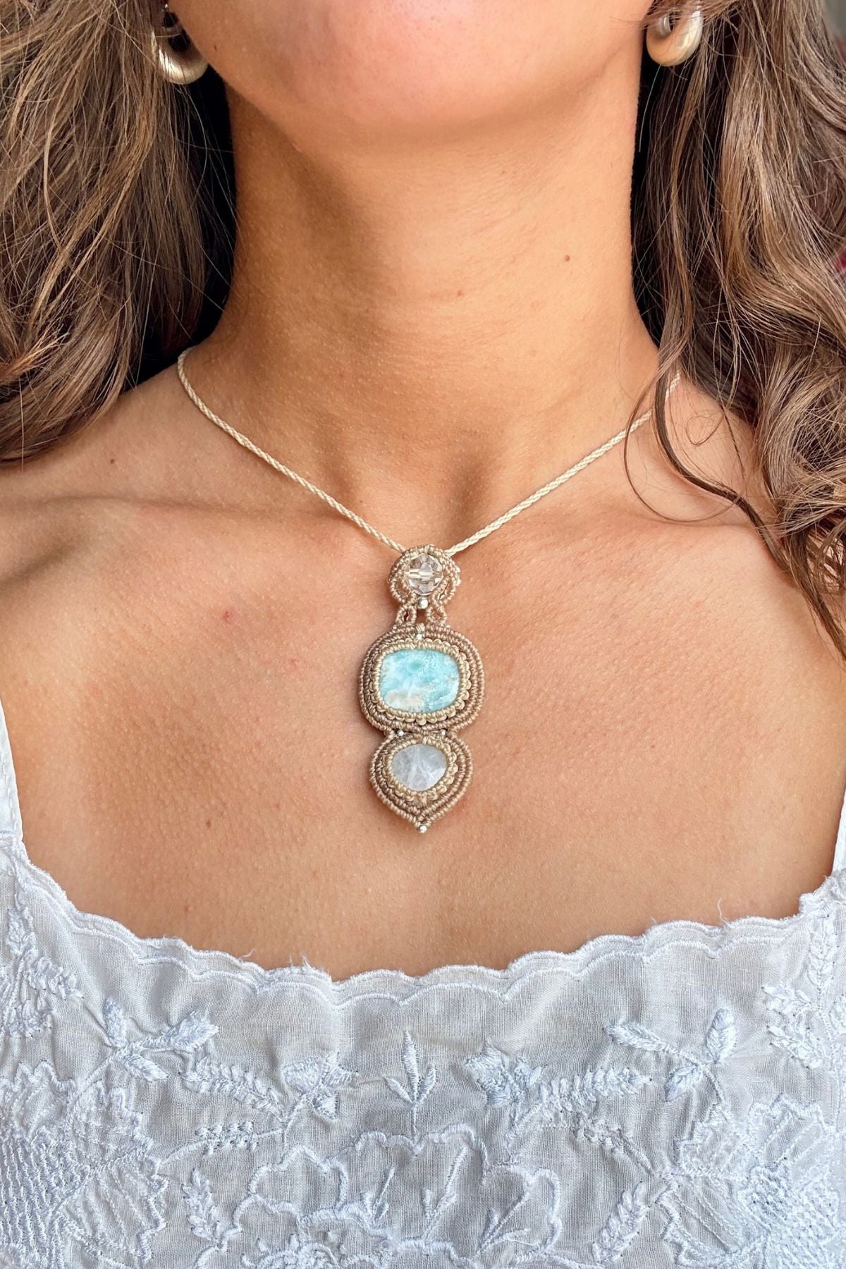 Larimar, Moonstone and quartz macrame pendant worn below the collarbones with a white embroidered top.