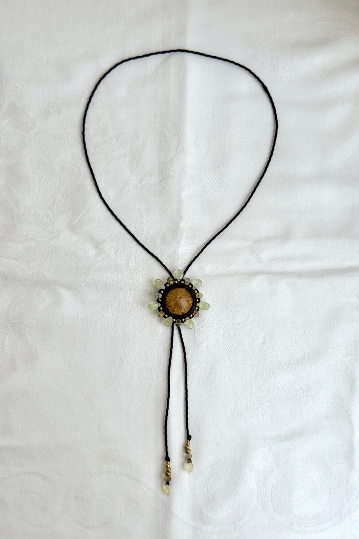 Sea urchin fossil bolo tie necklace with sun-inspired prehnite halo and rutilated quartz details, sculptural artisan jewelry