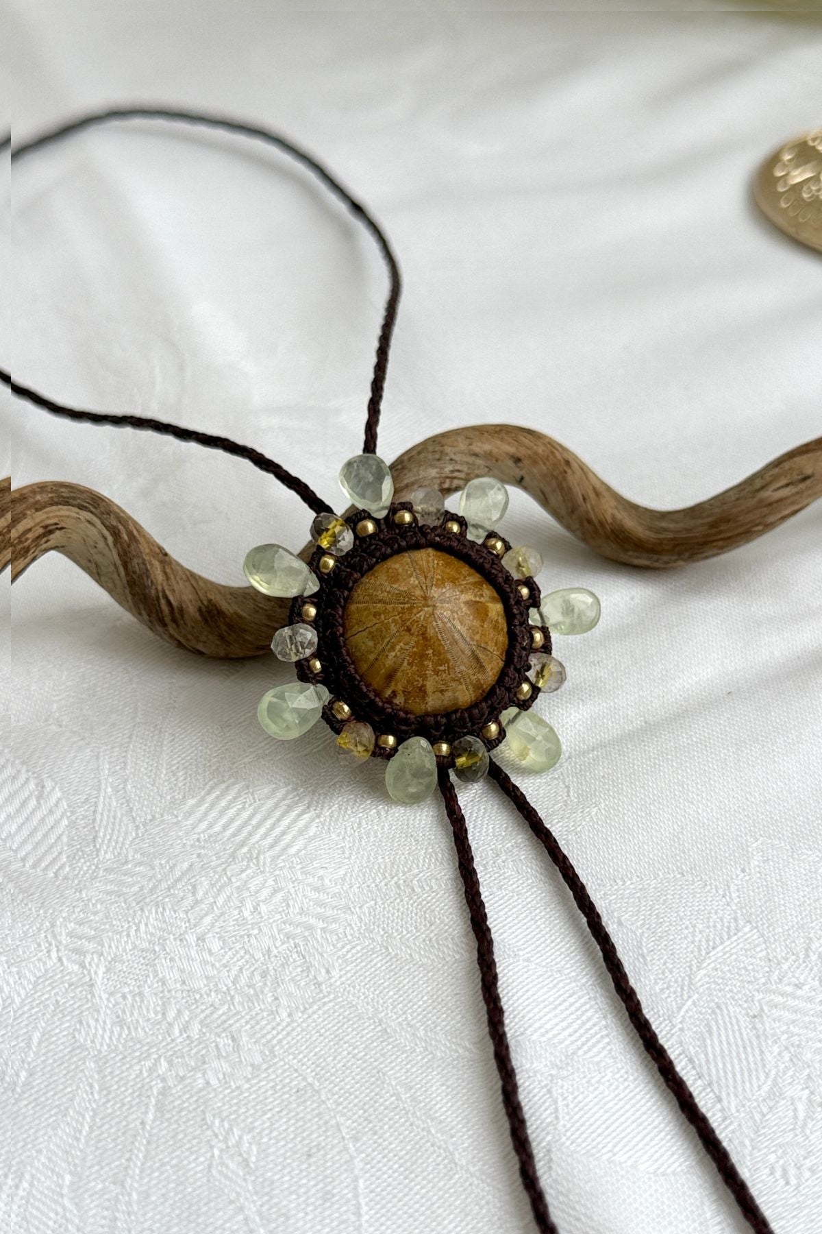 Detailed view of sea urchin fossil bolo tie with organic textures and gemstone embellishments