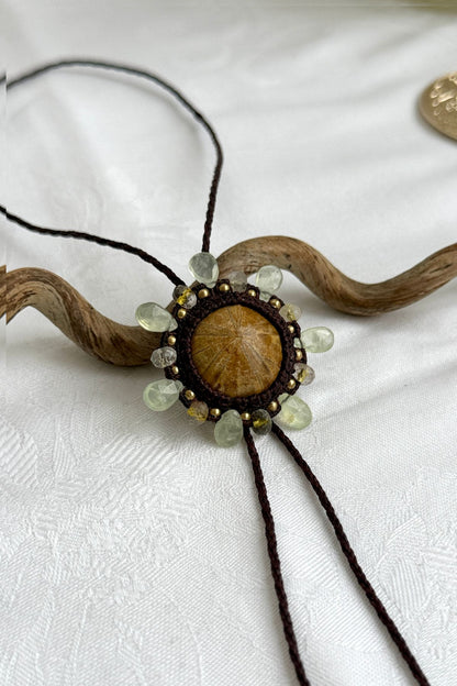 Detailed view of sea urchin fossil bolo tie with organic textures and gemstone embellishments