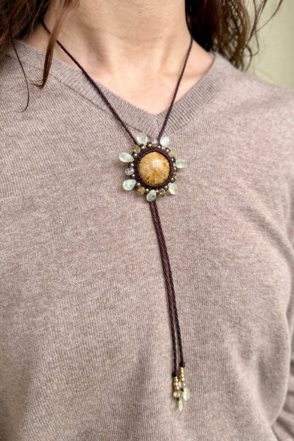 Model wearing sea urchin fossil bolo tie necklace with prehnite and rutilated quartz, ocean inspired statement jewelry