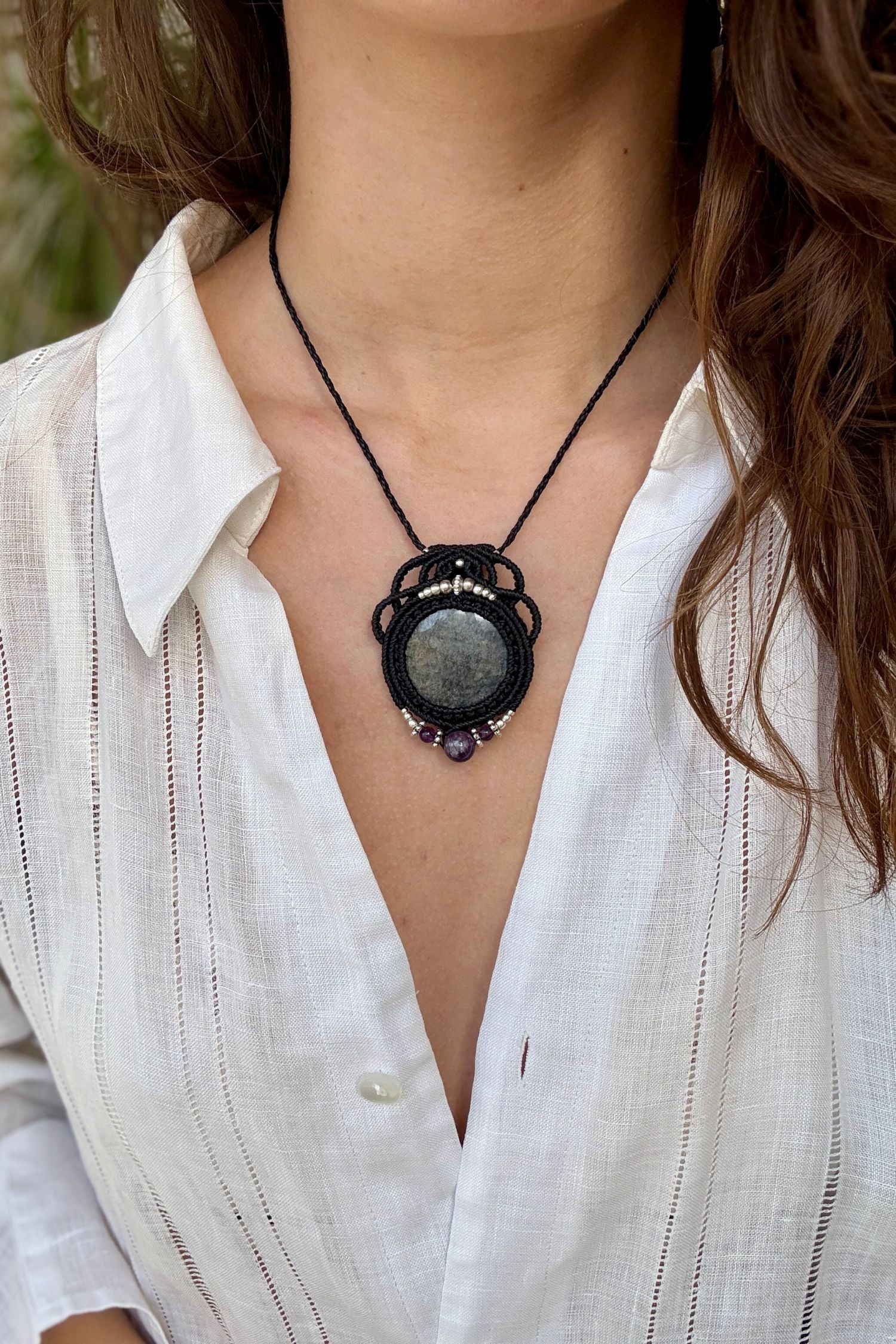 Silver Sheen Obsidian and Amethyst macrame necklace worn by a model. Showcasing the unique handmade design and how it looks when worn.