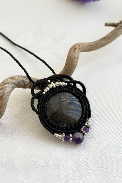 Side-angle view of the handmade macrame necklace with Silver Sheen Obsidian and Amethyst. Showcasing depth, knotting details, and stone textures.
