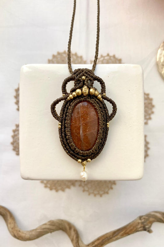 Handmade macrame necklace featuring a natural Sunstone gemstone and Pearl, crafted with a unique and artistic design, offering an adjustable length for a perfect fit.