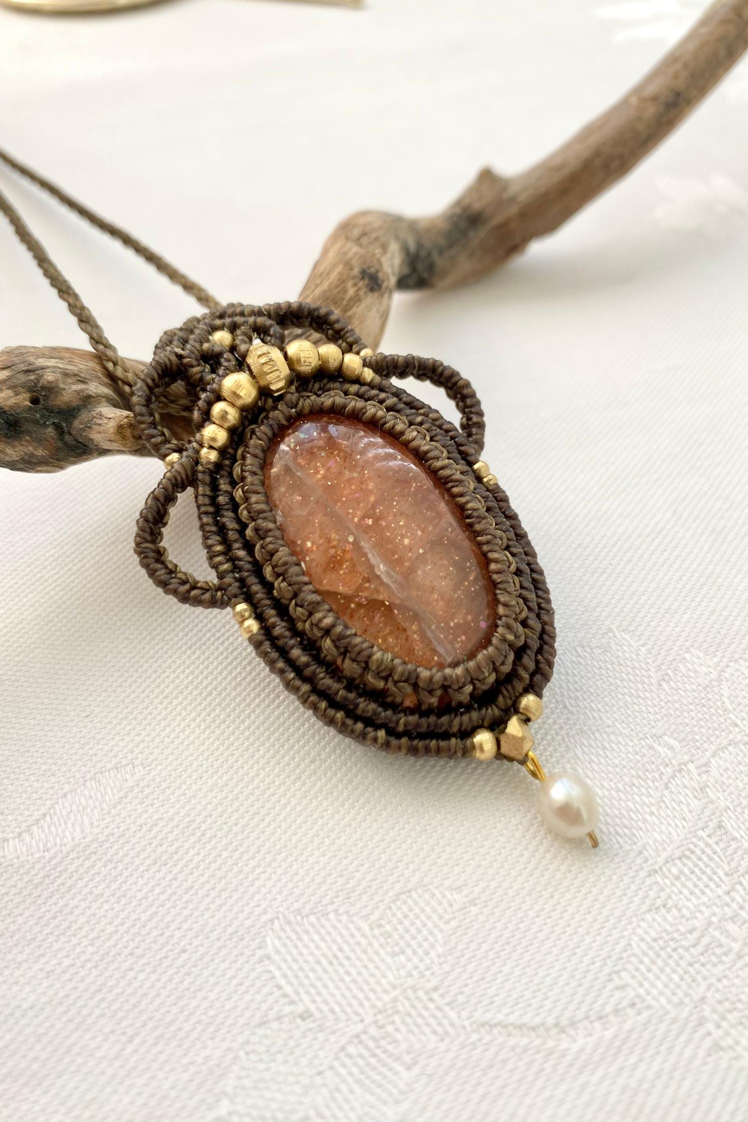 Side angle of the handcrafted macrame necklace, highlighting the detailed craftsmanship and the rich colors of Sunstone gemstone and Pearl.