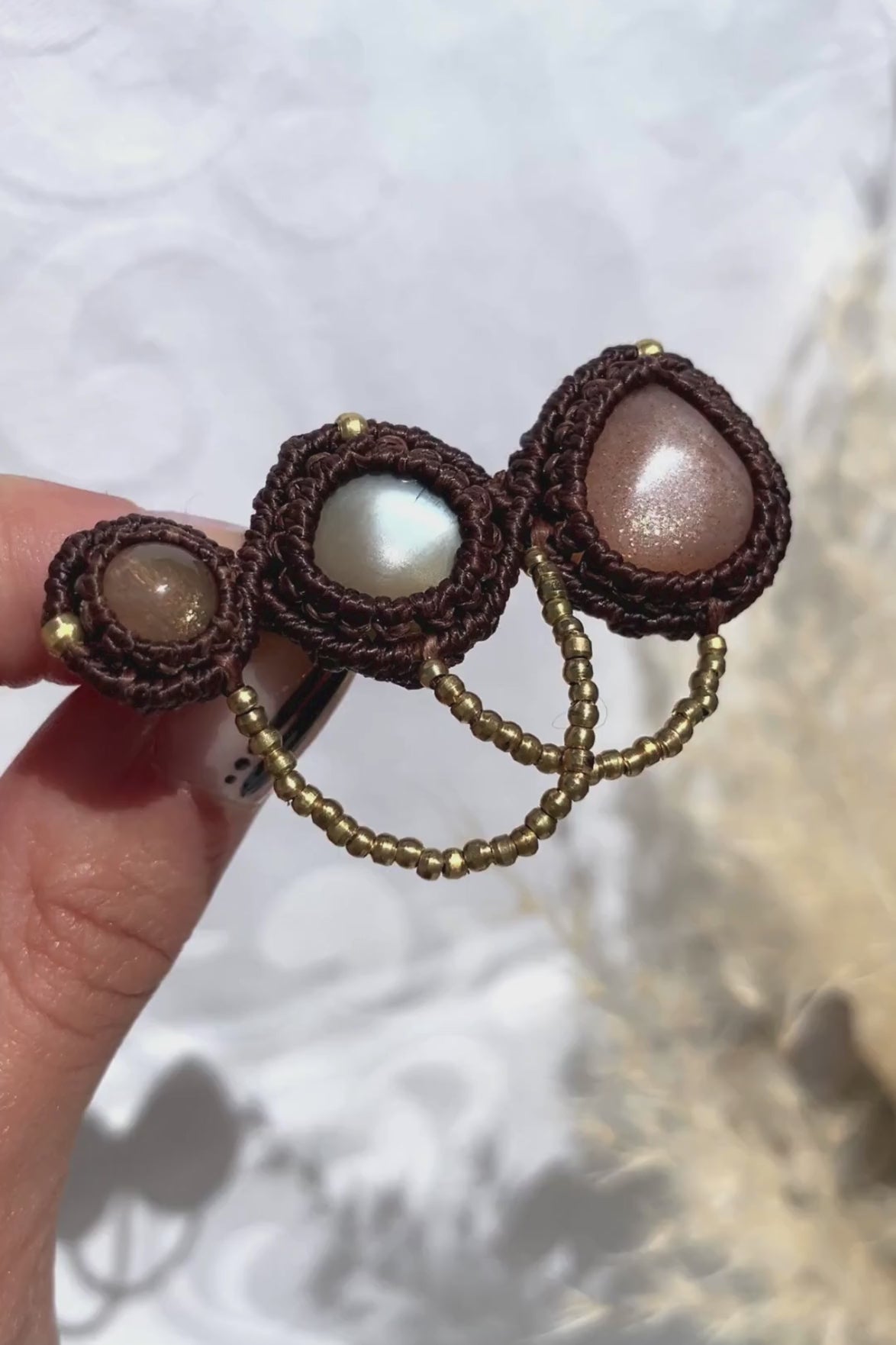 Close-up video of the handmade statement brooch, capturing the shimmer of the three Peach Moonstone gemstones and the intricate details of the design.