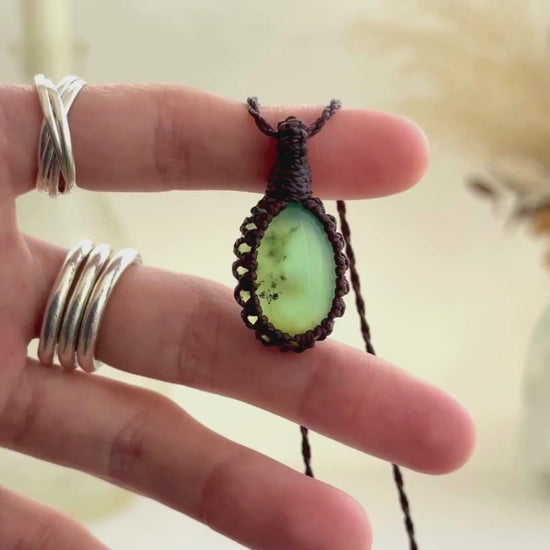 Video showcasing the harmonious vibrant green, semi-translucent Chrysoprase gemstone, held in hand with its brown macrame necklace.