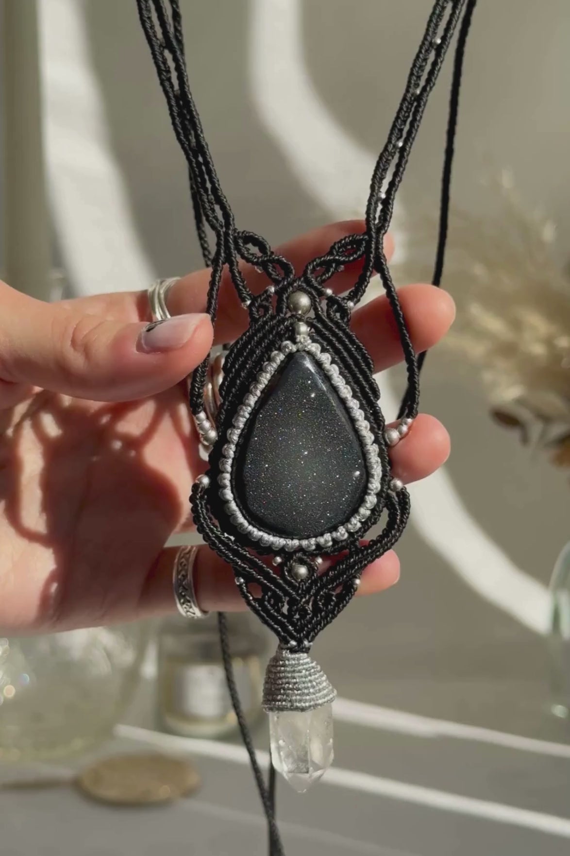 Video of a handmade Druzy Onyx and Clear Quartz point macrame necklace. Displaying natural gemstone colors, light reflections, and fine macrame details.
