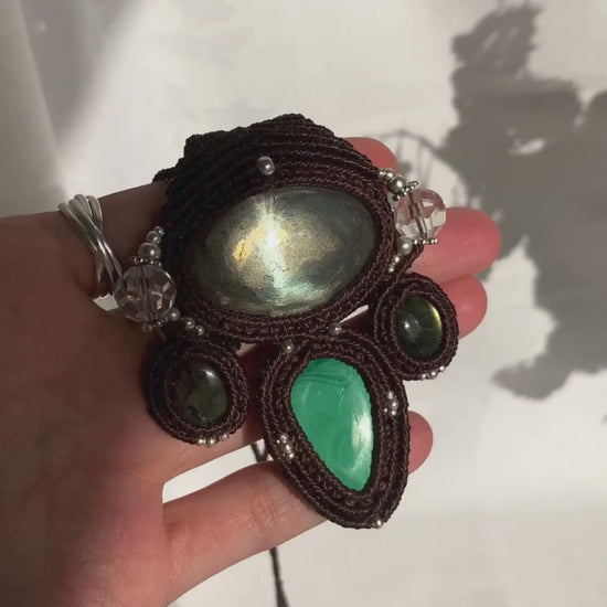 Close-up video of a handmade gemstone necklace, capturing the natural shine and intricate details of Pyrite, Labradorite, Malachite and Quartz beads. The unique design and polished gemstones reflect the light beautifully, highlighting the craftsmanship and one-of-a-kind artistry.
