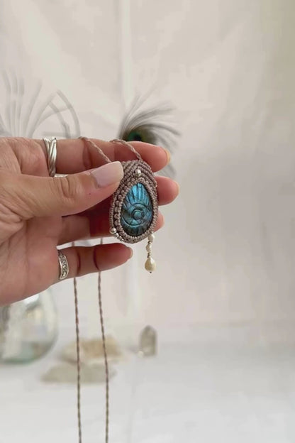 Video of Labradorite protective eye necklace, showing shifting blue hues and natural labradorescence of the gemstone, and the Fresh Water Pearl accents dangling.