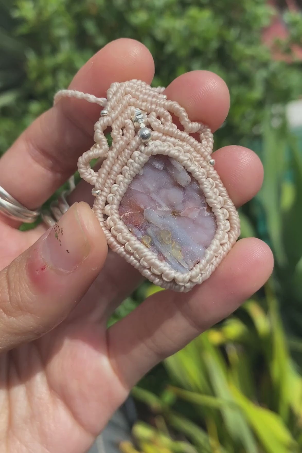 Close-up video of a handmade gemstone necklace, capturing the natural shine and intricate details of Raw Pink Chalcedony Stalactite. The unique design and polished gemstones reflect the light beautifully, highlighting the craftsmanship and one-of-a-kind artistry.