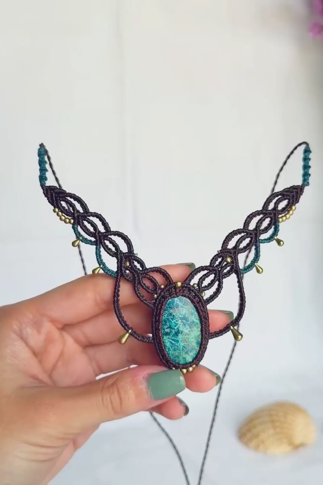 Video showing the chrysocolla stone’s blue-green colours and intricate natural veining in its brown macrame setting.